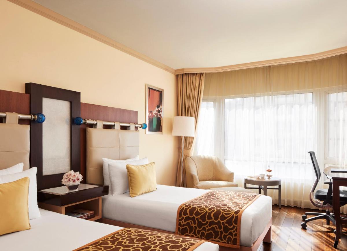 a hotel room with two beds and a desk at President - IHCL SeleQtions in Mumbai