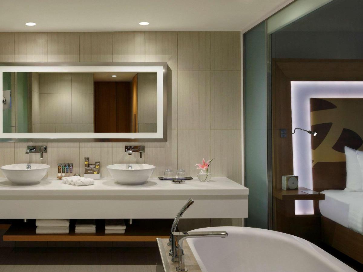 a bathroom with two sinks and a tub and a mirror at Novotel Chennai OMR in Chennai