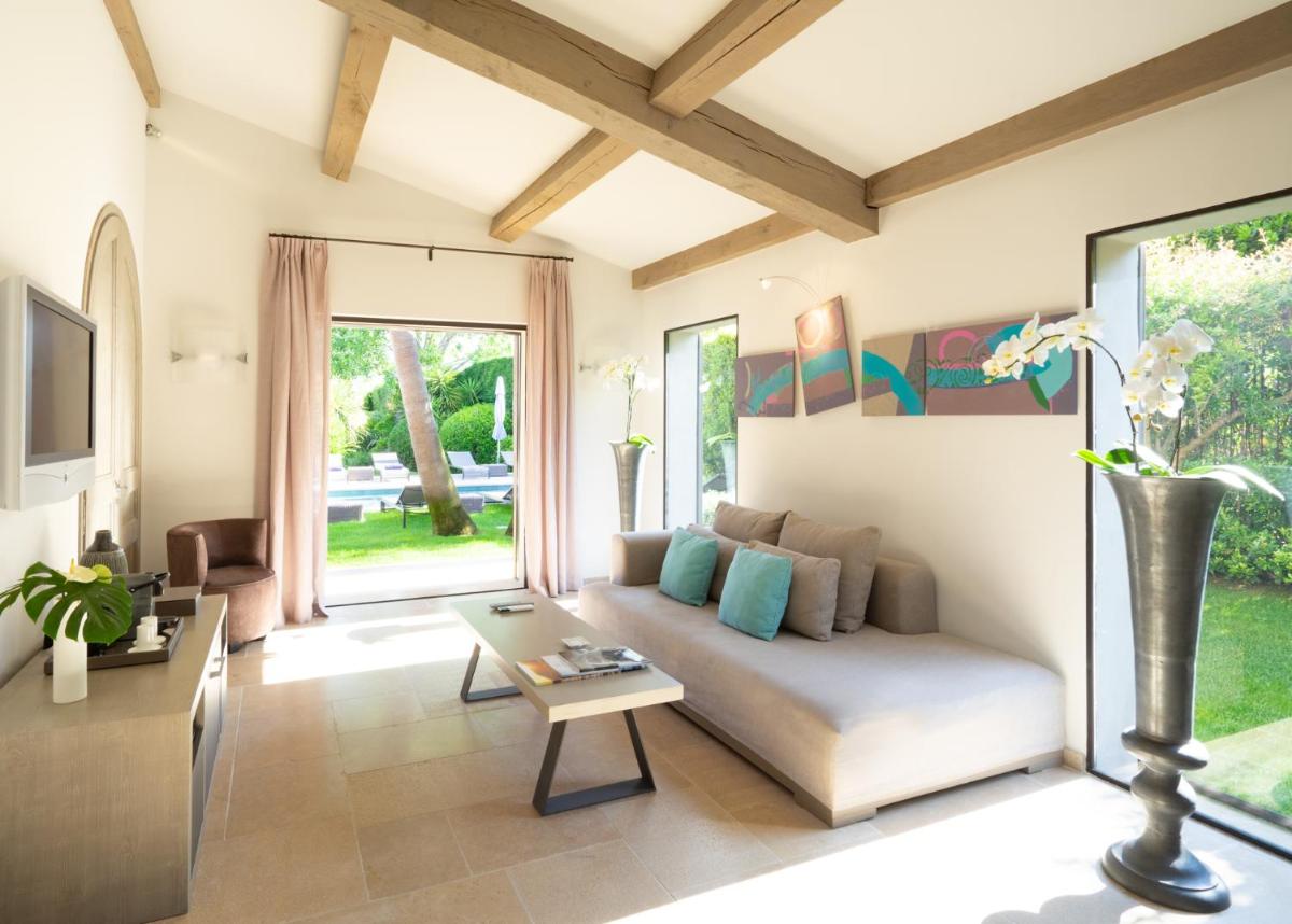 un salon avec un canapé et une table dans l'établissement Le Pre de la Mer, à Saint-Tropez