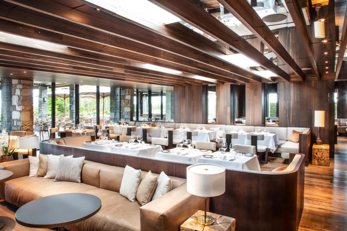 un restaurant avec des canapés et des tables dans une salle dans l'établissement Jiva Hill Resort - Genève, à Crozet