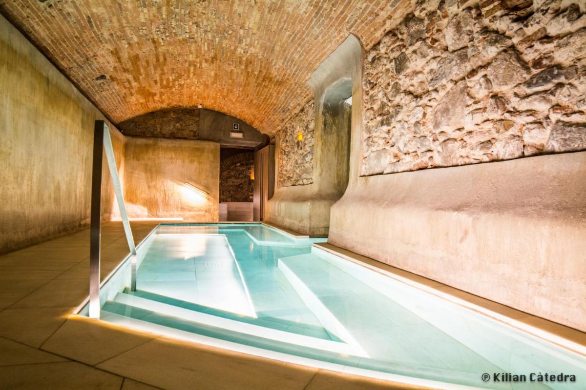 una piscina en un edificio con una pared de piedra en Balneari Termes Victòria, en Caldes de Montbui
