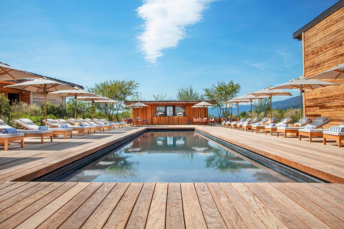 - une piscine avec des chaises et des parasols sur une terrasse en bois dans l'établissement Jiva Hill Resort - Genève, à Crozet