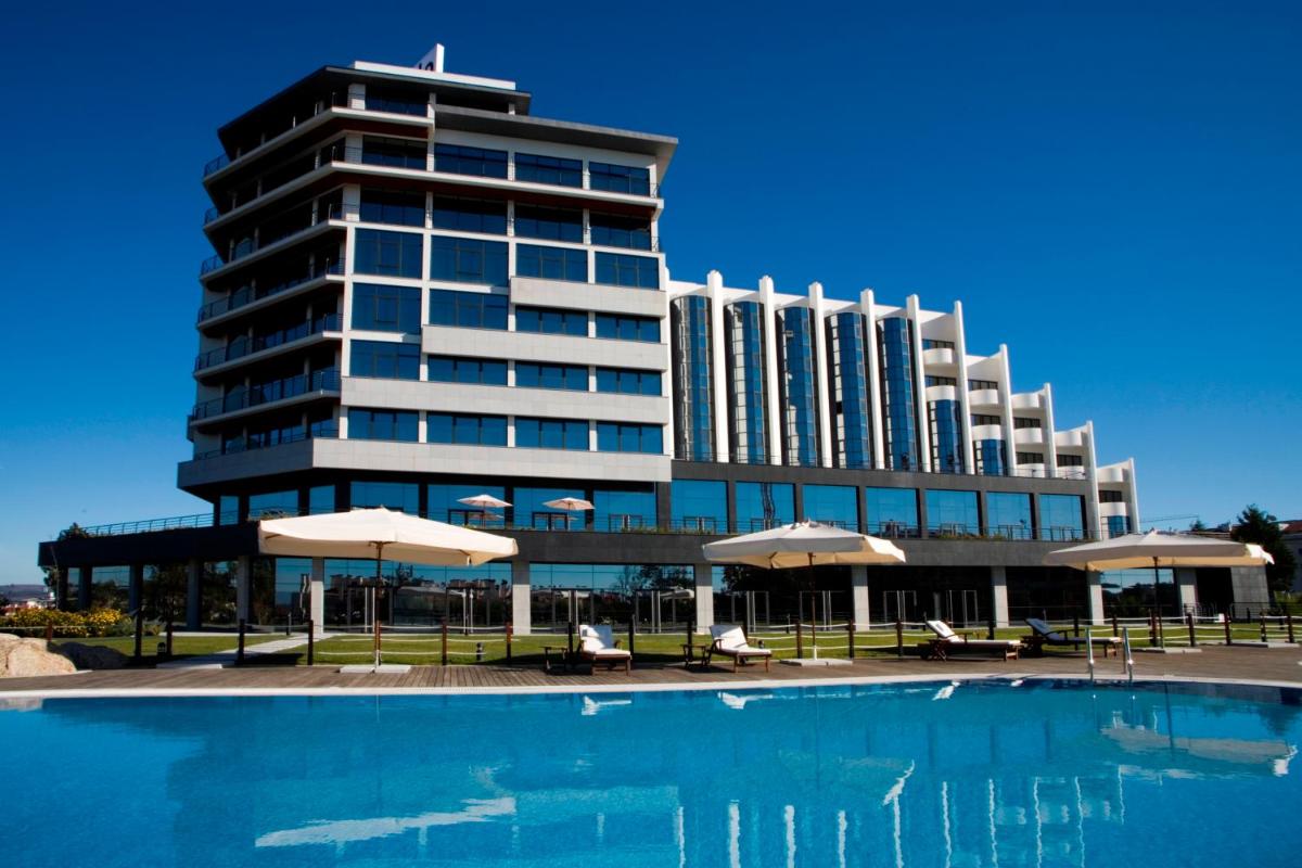 um prédio com piscina em frente a um prédio em Montebelo Viseu Congress Hotel & Spa em Viseu