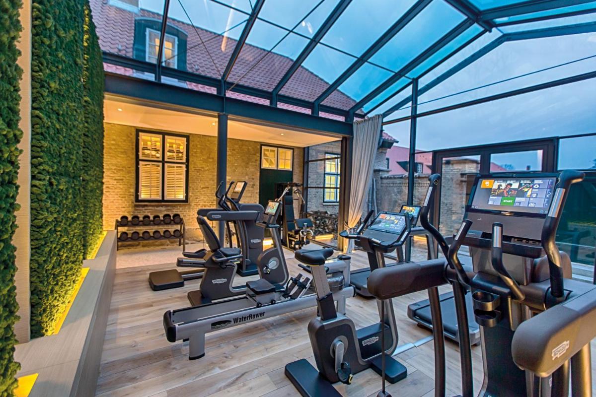 ein Fitnessstudio mit Laufbändern und Cardiogeräten in einem Gebäude in der Unterkunft Weissenhaus Private Nature Luxury Resort in Weißenhaus