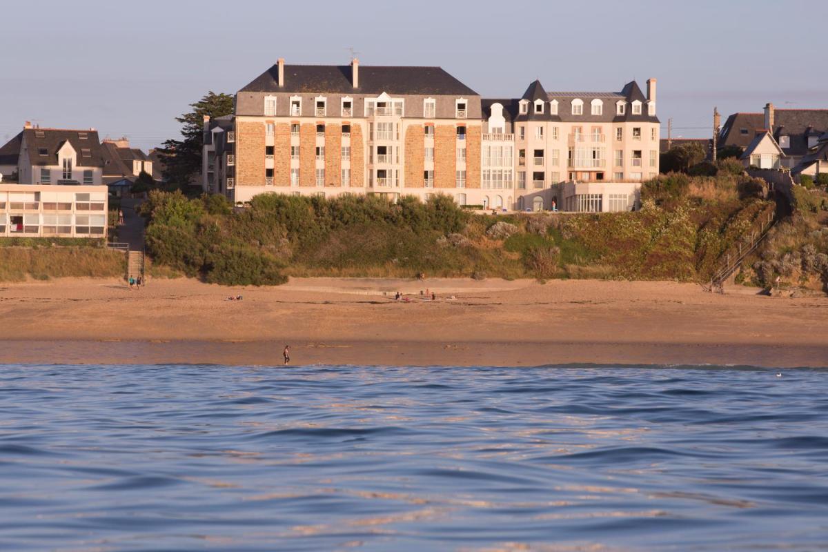 un grand bâtiment sur la plage à côté d'une plage dans l'établissement Residence Reine Marine, à Saint-Malo