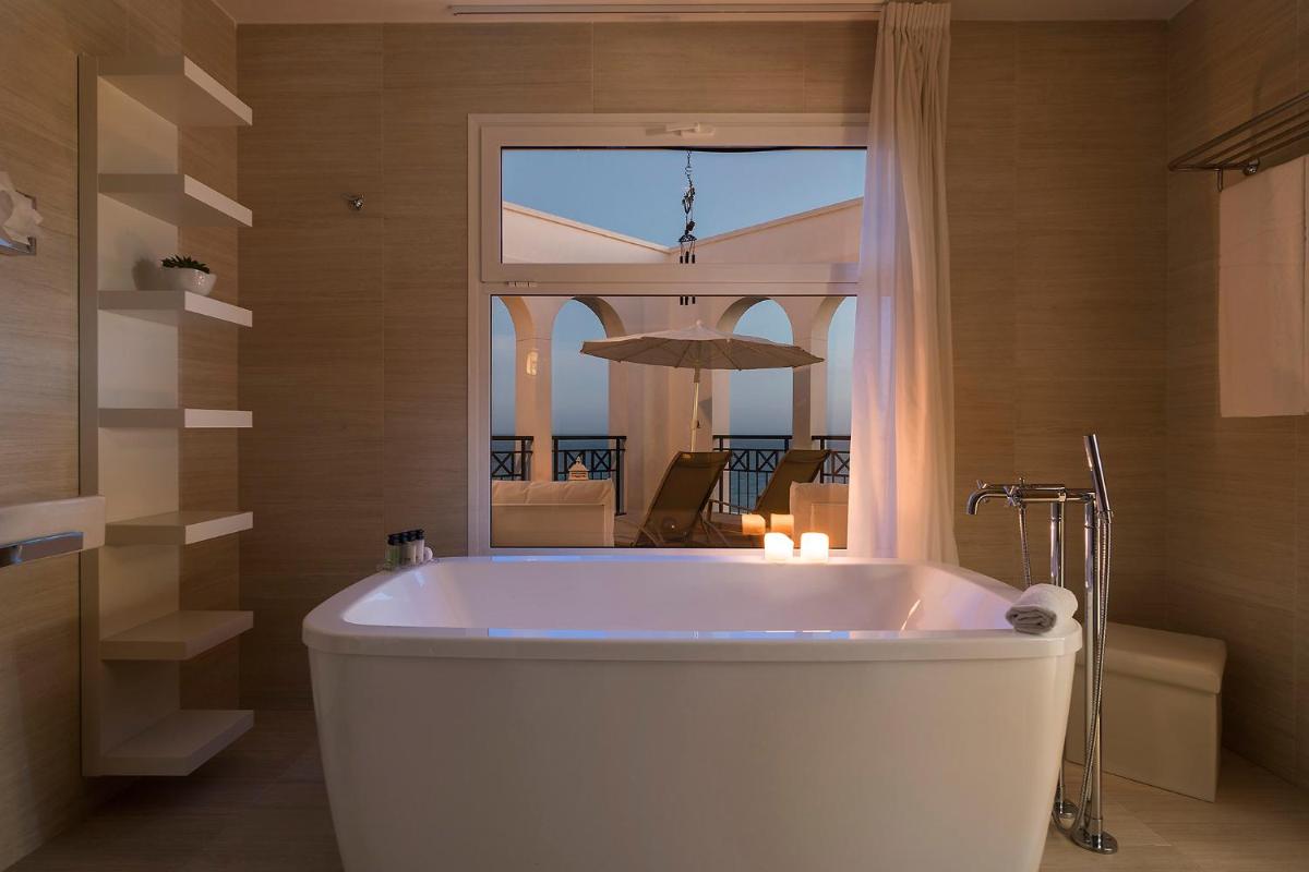Una bañera en un baño con una ventana grande. en Royal Palm Resort & Spa - Adults Only, en Playa de Jandía