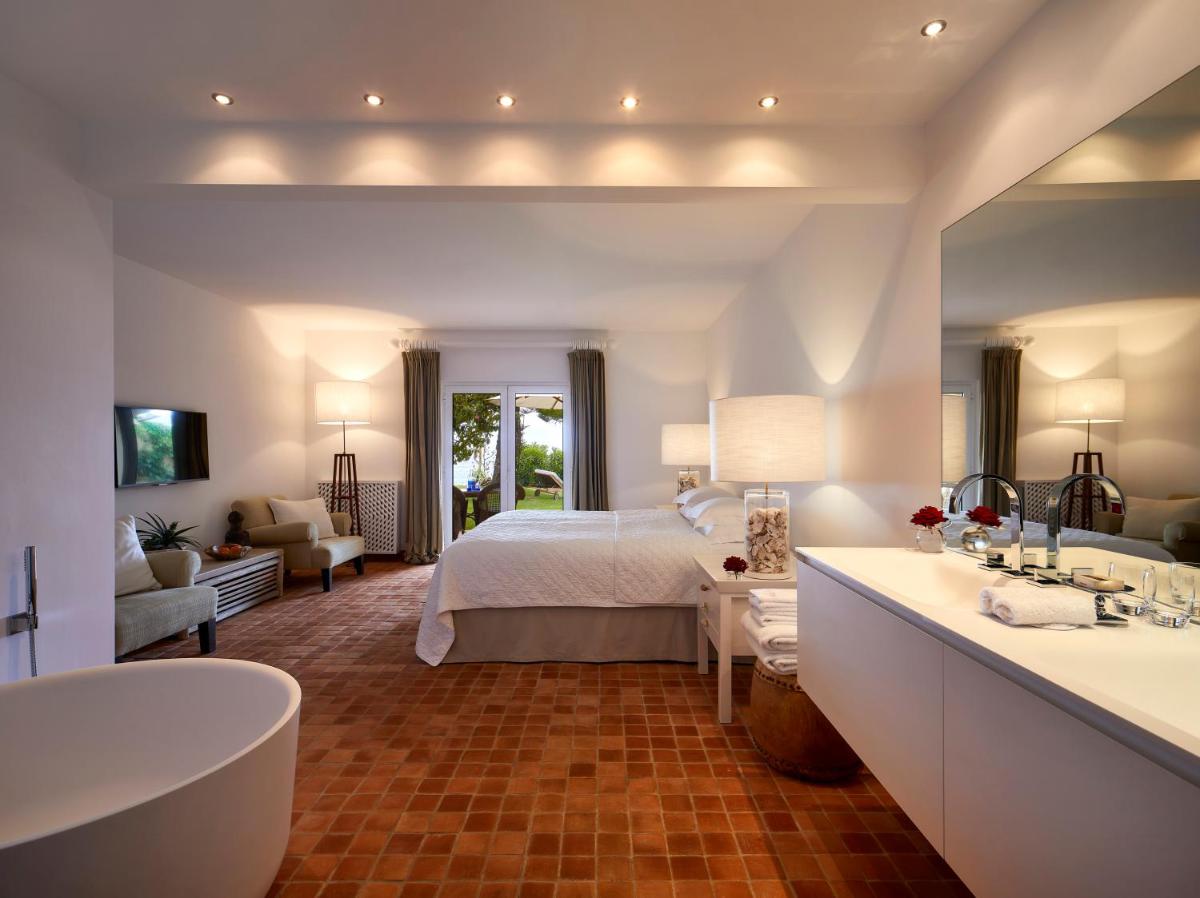 um quarto com uma cama e uma banheira em um cômodo em Vila Joya em Albufeira um quarto com uma cama e uma banheira em um cômodo em Vila Joya em Albufeira