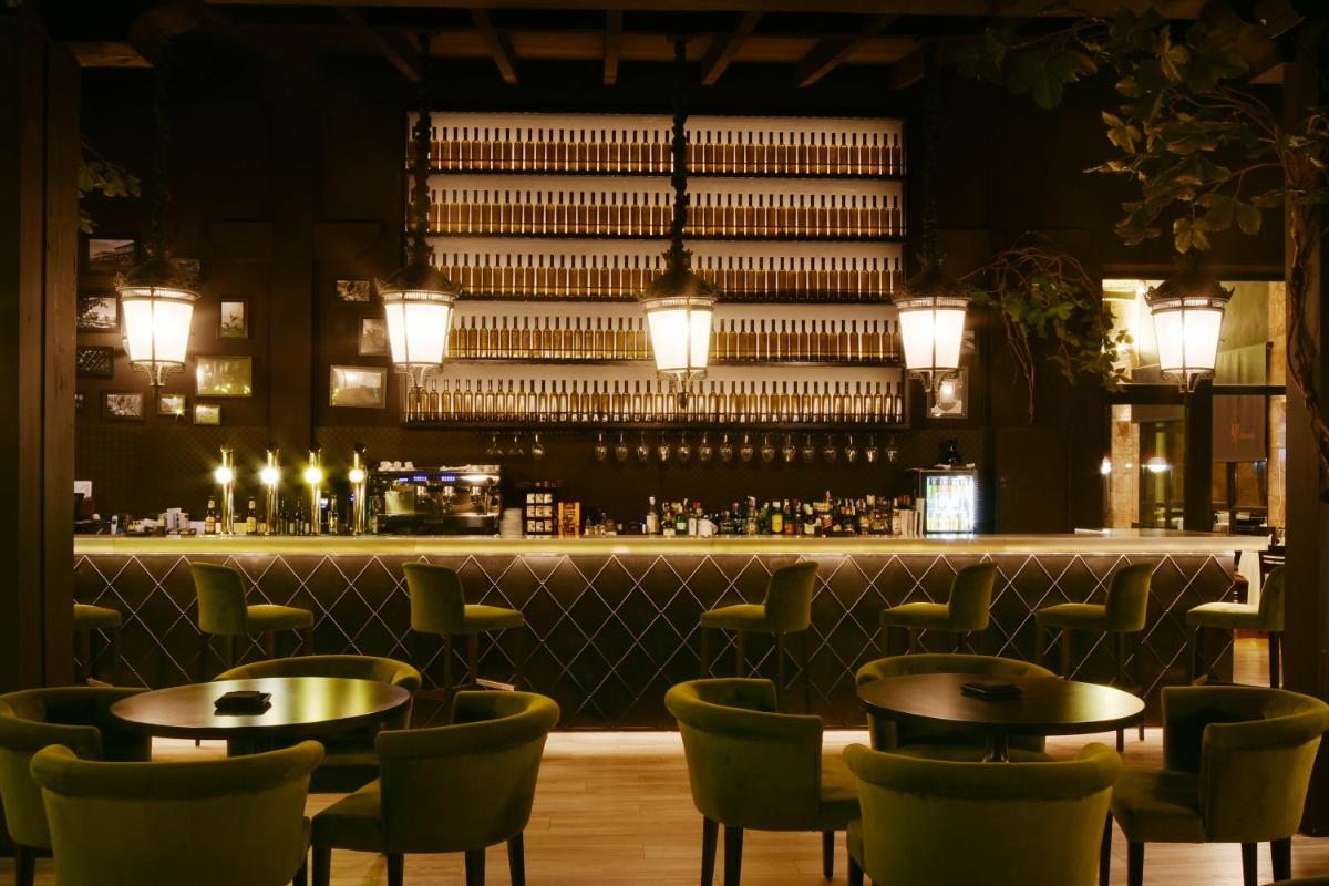 Un restaurante con mesas y sillas y un bar. en Complejo Enoturístico Finca La Estacada, en Tarancón