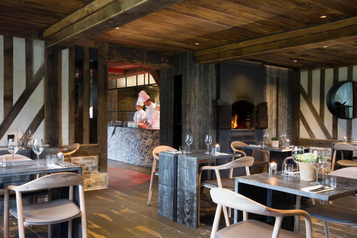 un restaurant avec des plafonds en bois, des tables et des chaises dans l'établissement La Ferme Saint Simeon Spa - Relais & Chateaux, à Honfleur un restaurant avec des plafonds en bois, des tables et des chaises dans l'établissement La Ferme Saint Simeon Spa - Relais & Chateaux, à Honfleur