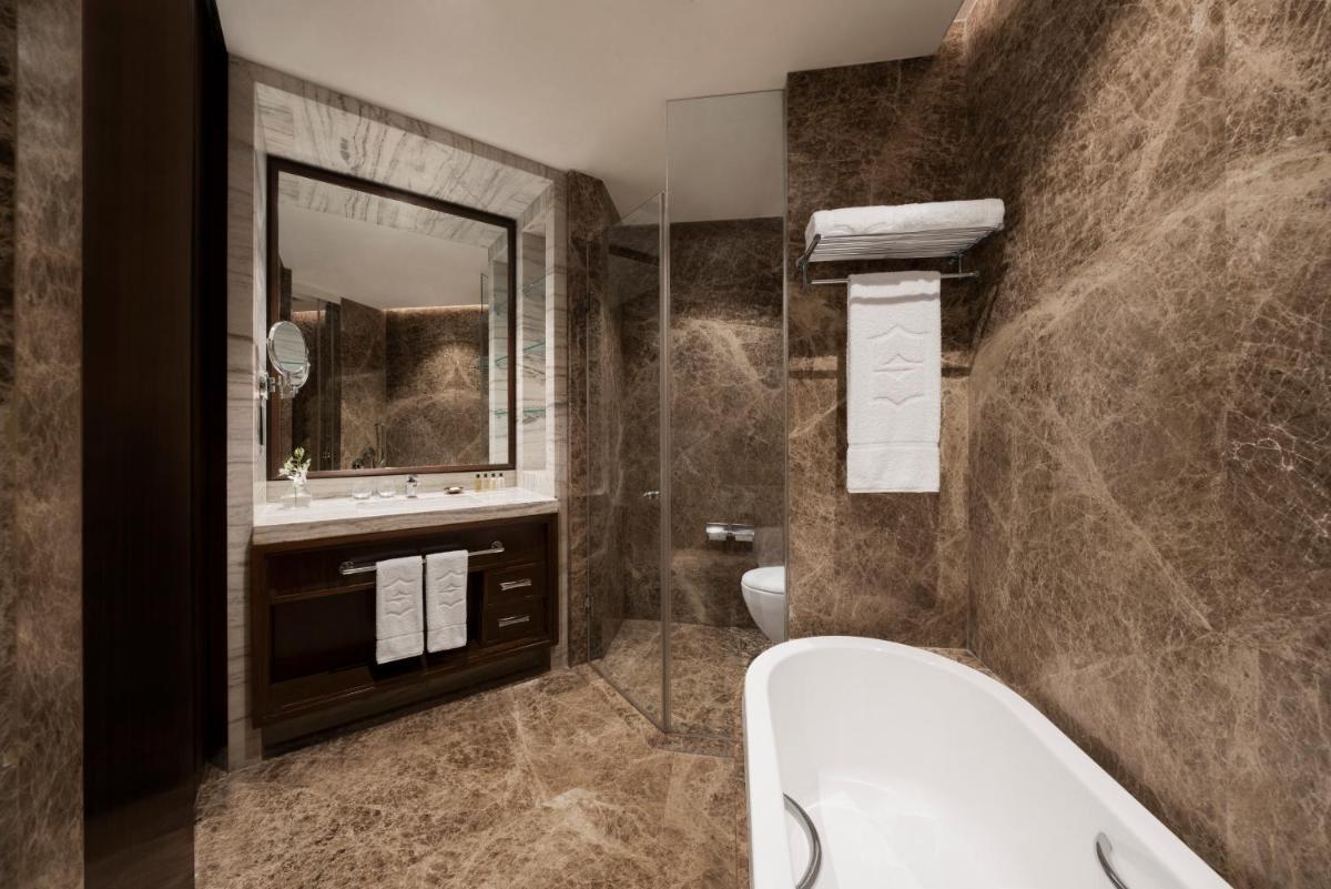 a bathroom with a tub and a sink at Shangri-La Eros New Delhi in New Delhi a bathroom with a tub and a sink at Shangri-La Eros New Delhi in New Delhi