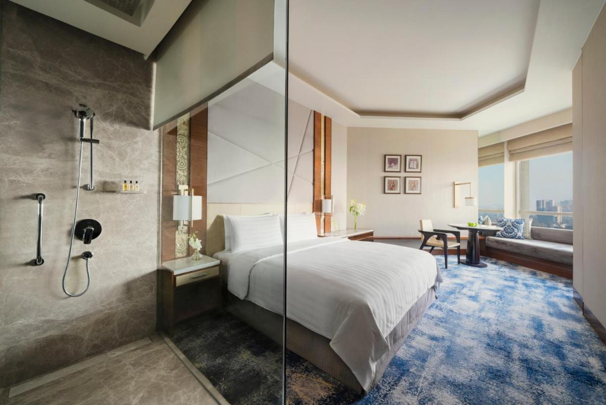 a hotel room with a bed and a shower at Shangri-La Eros New Delhi in New Delhi a hotel room with a bed and a shower at Shangri-La Eros New Delhi in New Delhi