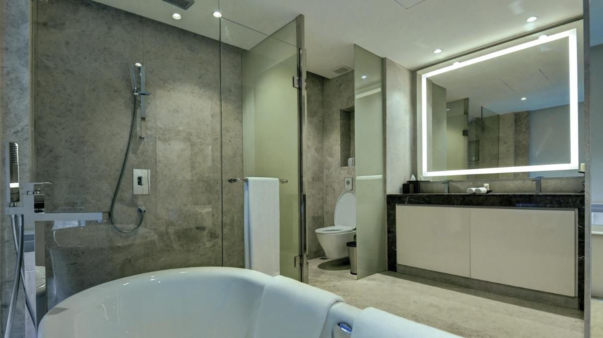 a bathroom with a tub and a shower and a toilet at Hyatt Regency Delhi in New Delhi a bathroom with a tub and a shower and a toilet at Hyatt Regency Delhi in New Delhi