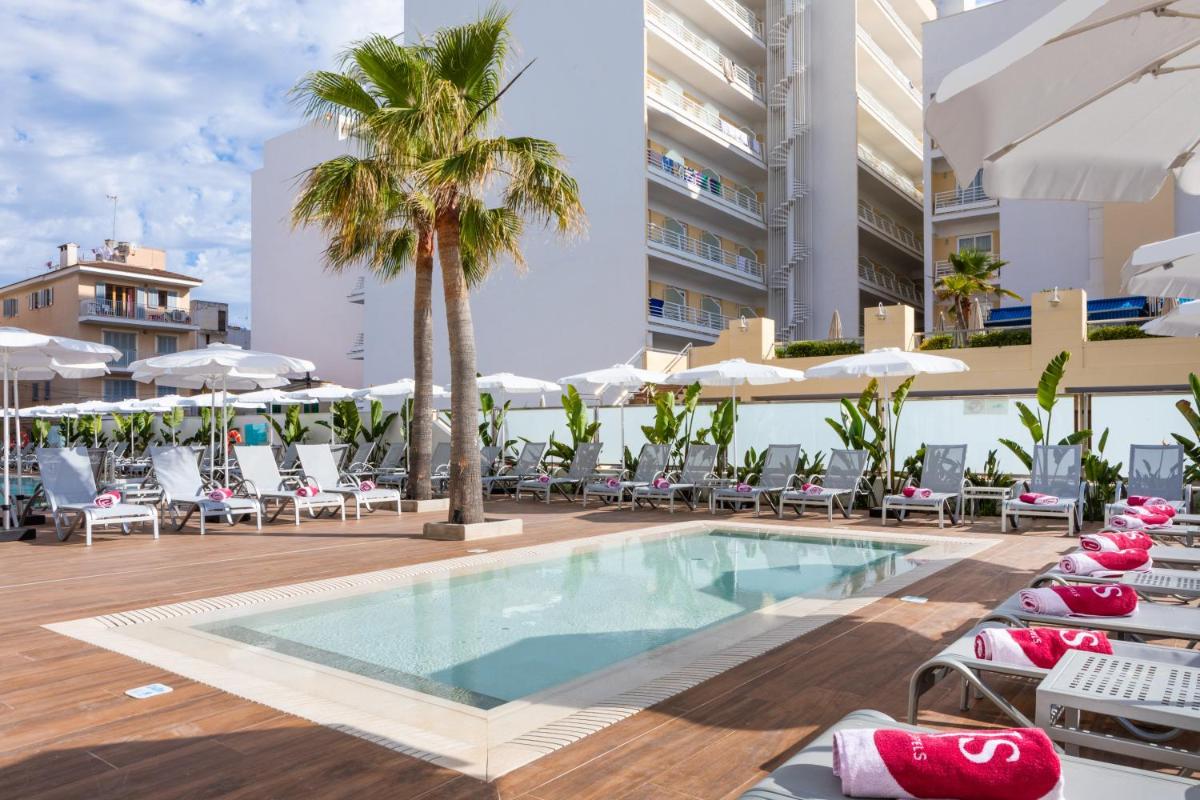 una piscina en un hotel con sillas y una palmera en JS Yate, en Can Picafort