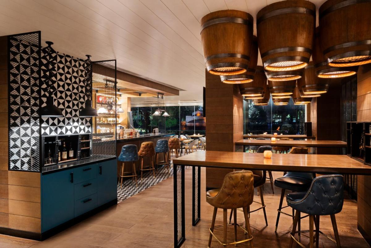 a restaurant with a bar with tables and chairs at Shangri-La Eros New Delhi in New Delhi a restaurant with a bar with tables and chairs at Shangri-La Eros New Delhi in New Delhi