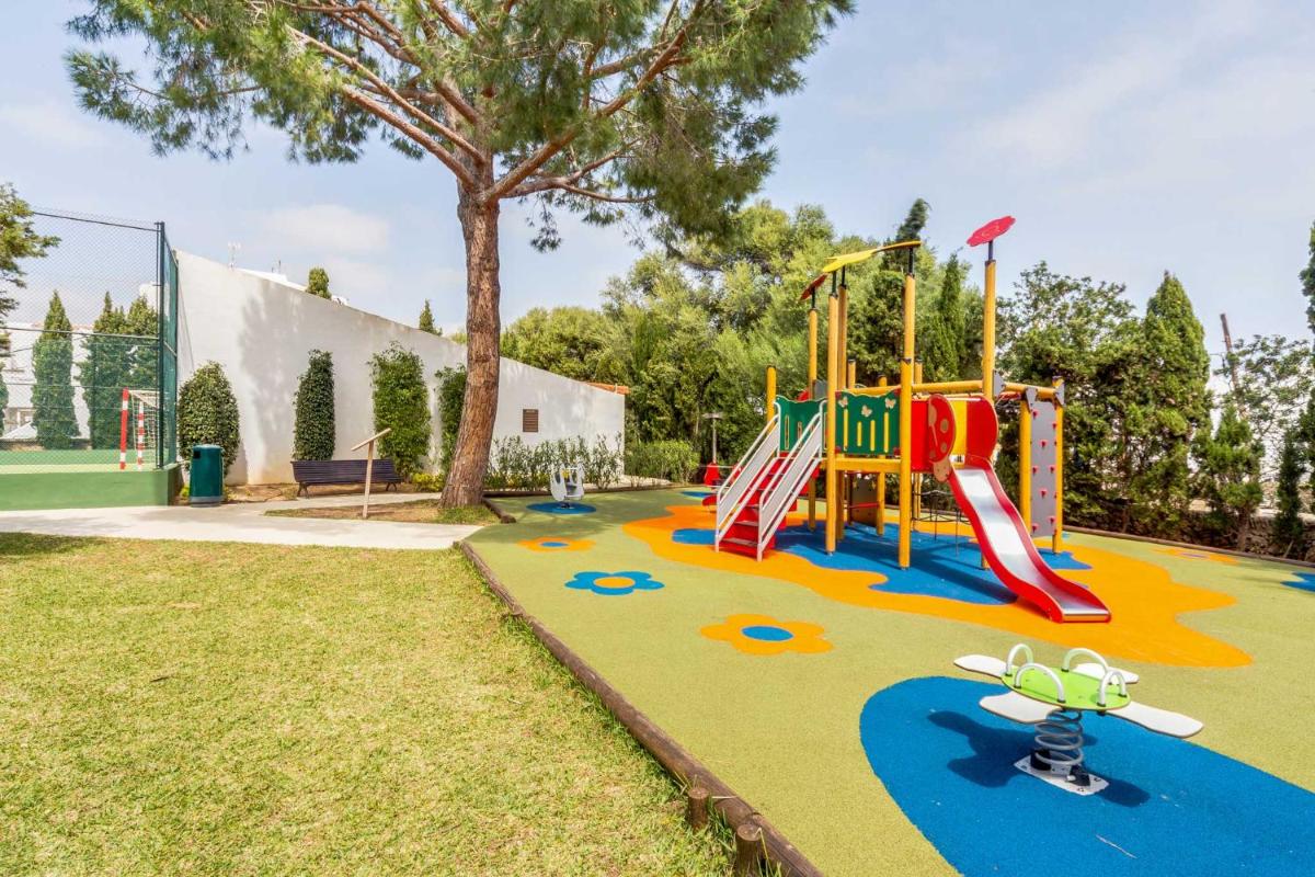 un patio de recreo con un tobogán en un parque en Inturotel Cala Azul, en Cala d´Or
