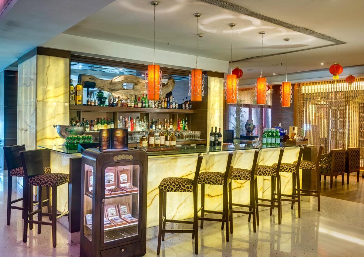 a bar with a bunch of chairs in a room at Hotel Hindusthan International, Kolkata in Kolkata