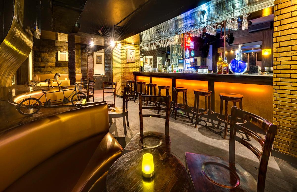 a bar with a wooden table and some chairs at Hotel Hindusthan International, Kolkata in Kolkata