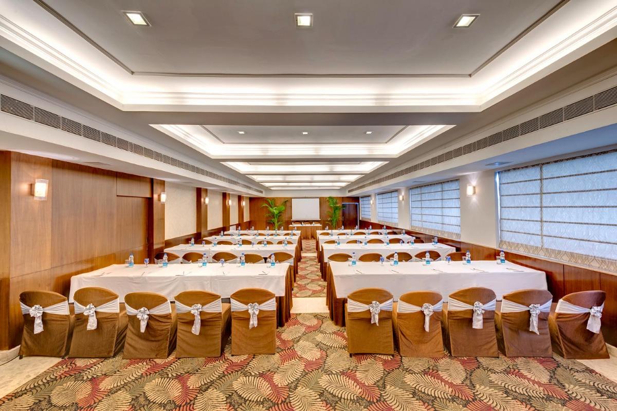 a banquet hall with white tables and chairs at Hotel Hindusthan International, Kolkata in Kolkata
