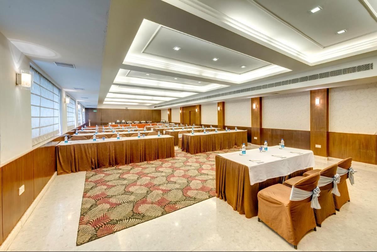 a large room with rows of tables and chairs at Hotel Hindusthan International, Kolkata in Kolkata