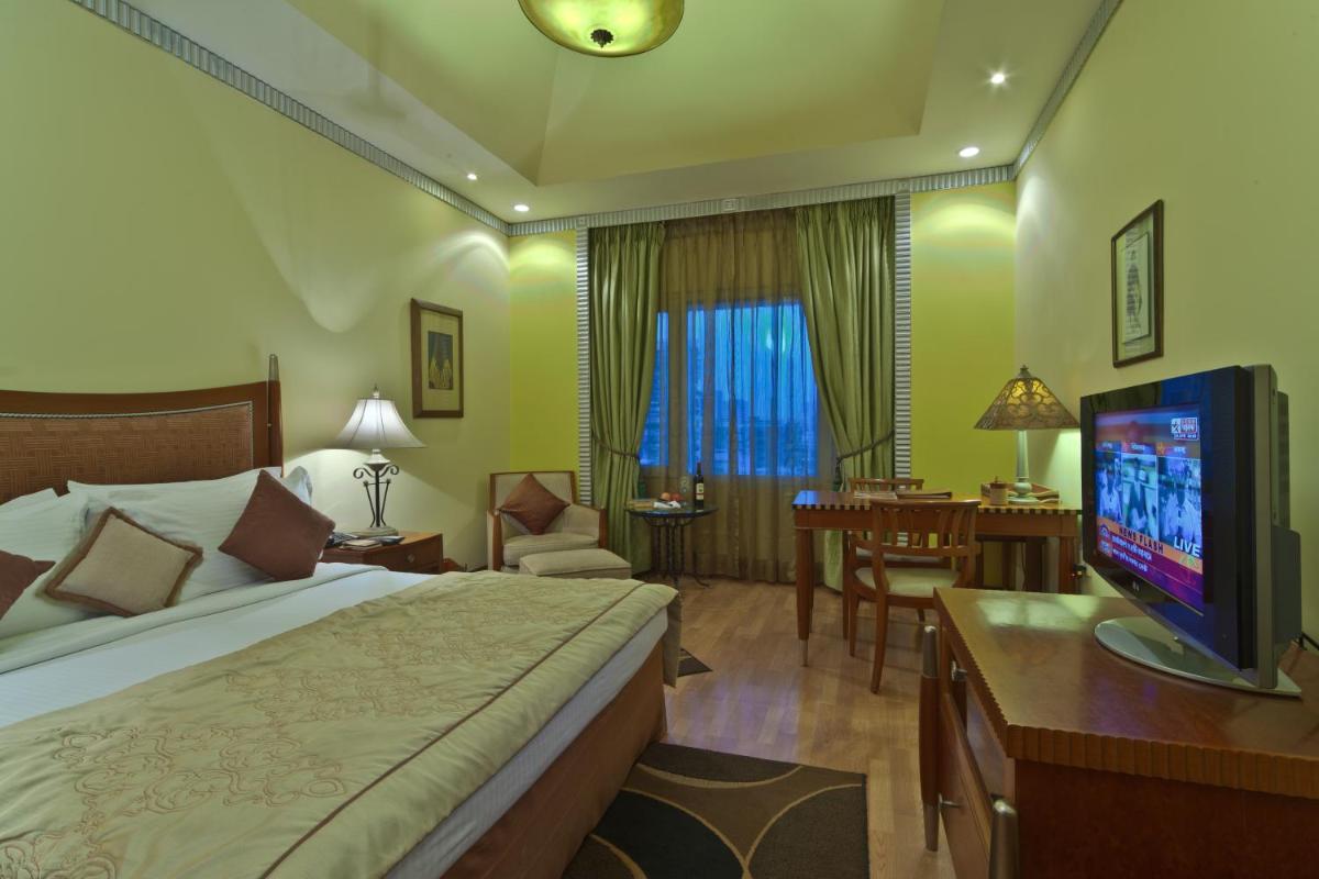 a hotel room with a bed and a flat screen tv at Hotel Hindusthan International, Kolkata in Kolkata