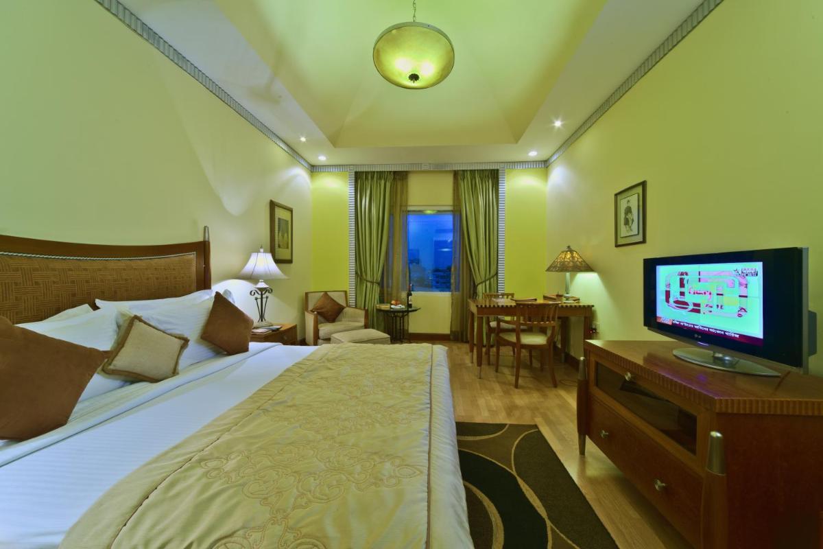 a hotel room with a bed and a flat screen tv at Hotel Hindusthan International, Kolkata in Kolkata