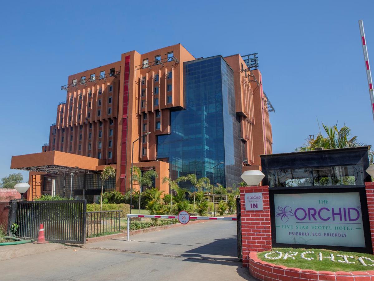 a building with a sign in front of it at The Orchid Hotel Hinjewadi Pune in Pune a building with a sign in front of it at The Orchid Hotel Hinjewadi Pune in Pune