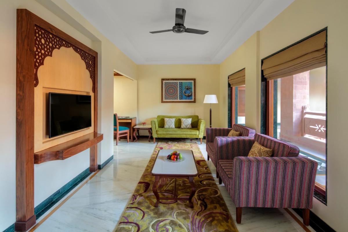 a living room with two chairs and a flat screen tv at Radisson Jodhpur in Jodhpur