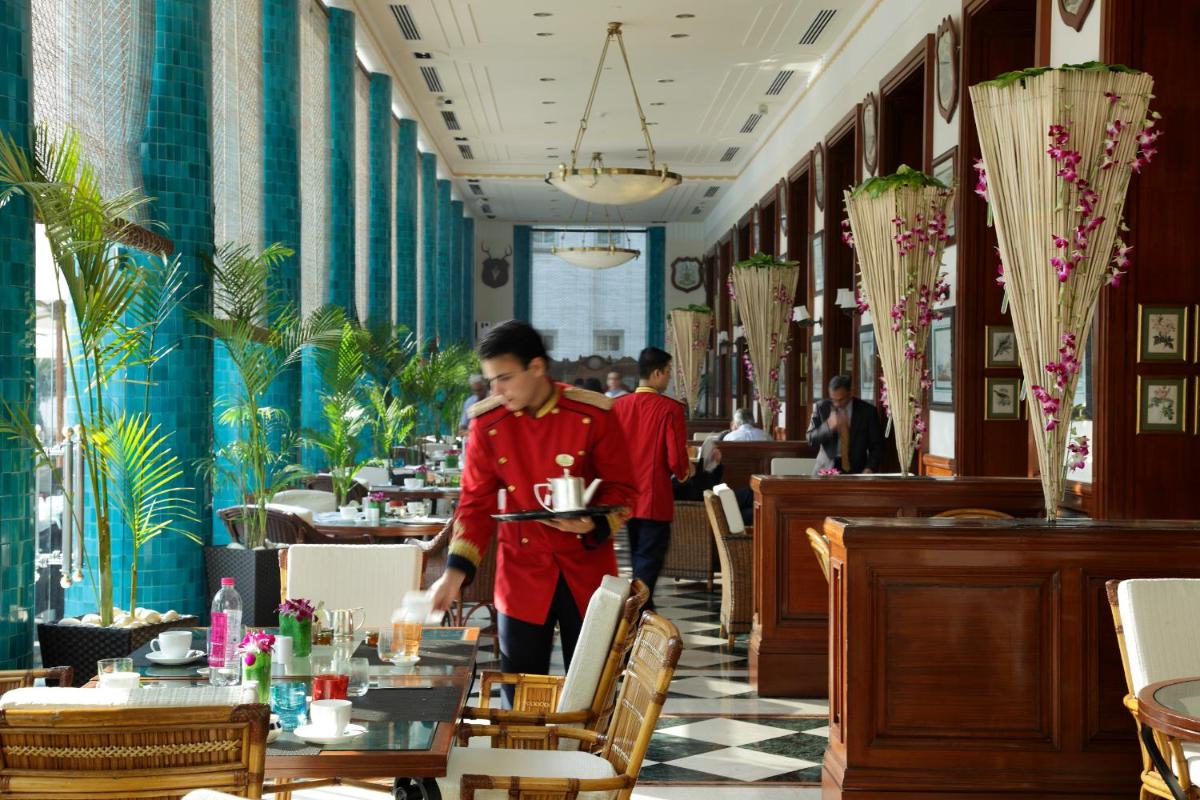 a man is standing in a restaurant dining room at The Imperial, New Delhi in New Delhi a man is standing in a restaurant dining room at The Imperial, New Delhi in New Delhi