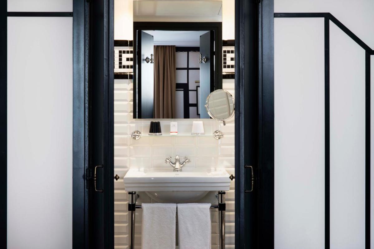une salle de bain avec un lavabo et un miroir dans l'établissement Hotel Monsieur & Spa, à Paris