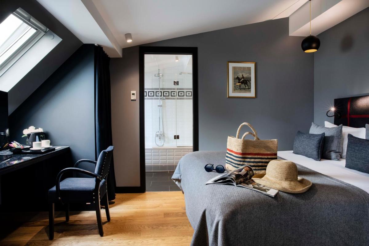 une chambre avec un lit avec un chapeau dessus dans l'établissement Hotel Monsieur & Spa, à Paris
