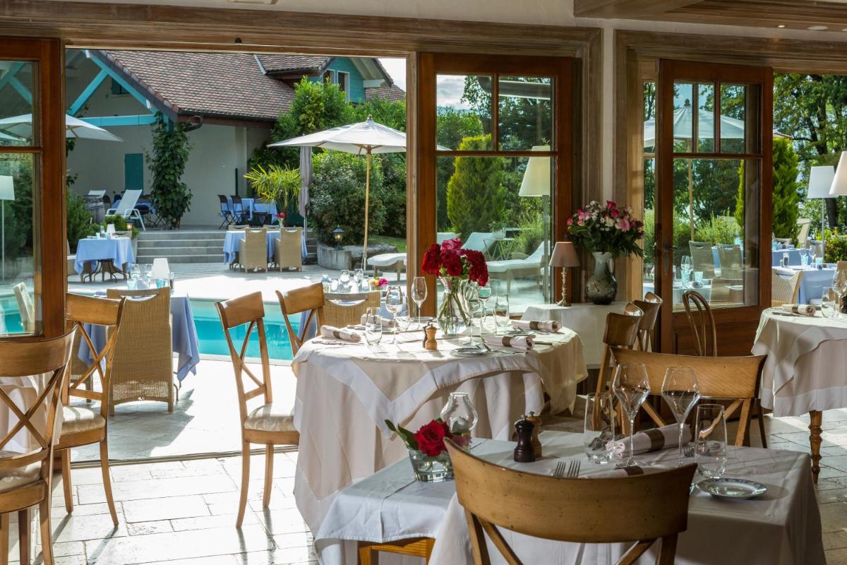 une salle à manger avec des tables et des nappes blanches dans l'établissement Villa Cécile, à Yvoire