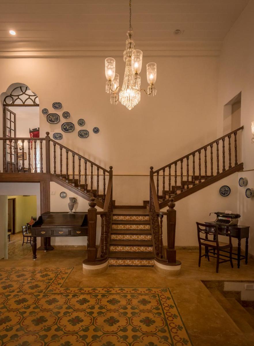 a living room with a staircase and a chandelier at The Postcard Cuelim, Goa in Cansaulim