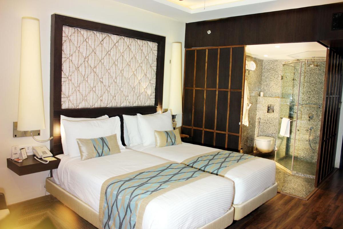 a bedroom with a large bed and a shower at Clarks Avadh in Lucknow