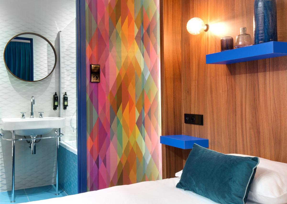 une salle de bain avec un lit, un lavabo et un miroir dans l'établissement Hôtel Montmorency & Spa, à Carcassonne 150 autres photos