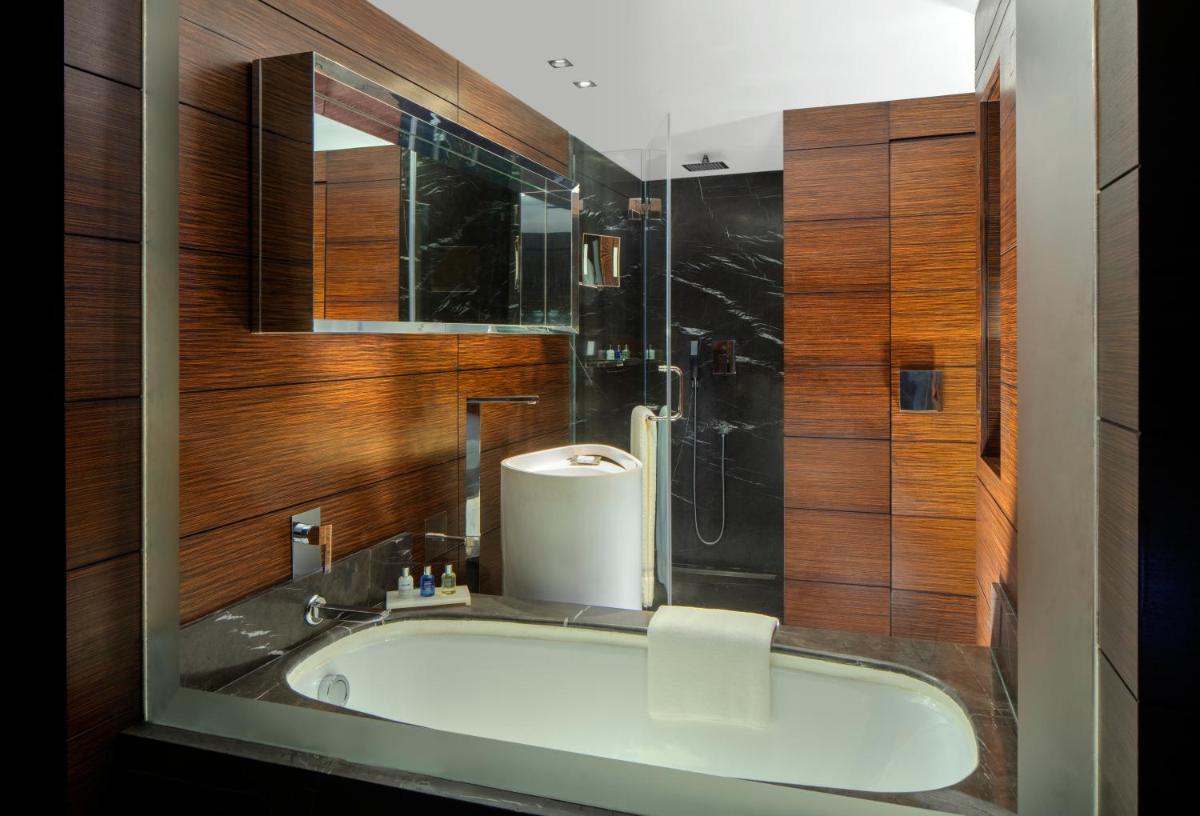 a bathroom with a bath tub and a shower at Radisson Blu Atria Bengaluru in Bengaluru a bathroom with a bath tub and a shower at Radisson Blu Atria Bengaluru in Bengaluru