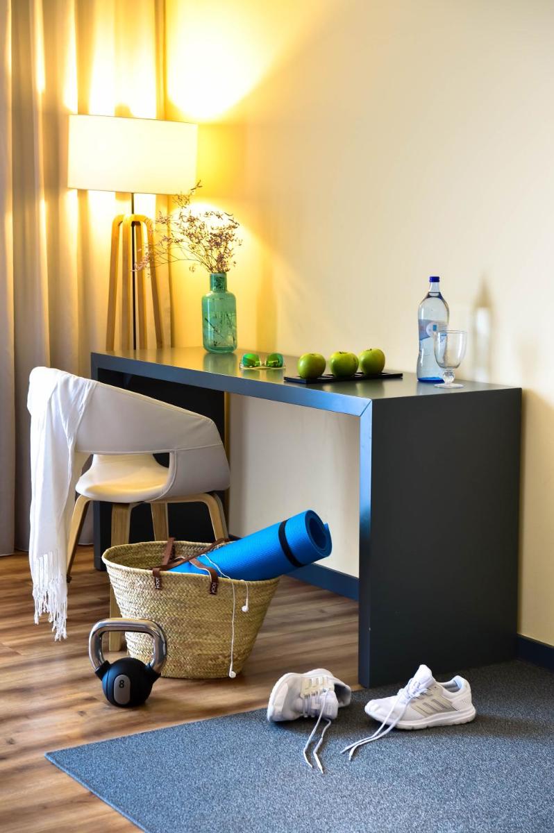 uma sala com uma escrivaninha, uma cadeira e uma mesa em The Prime Energize Hotel & SPA - Algarve em Monte Gordo