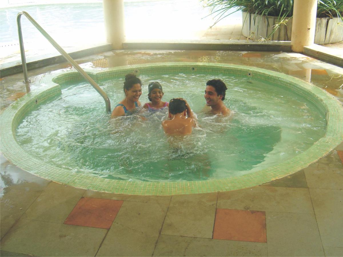 a group of people in a swimming pool at The Retreat Hotel & Convention Centre in Mumbai