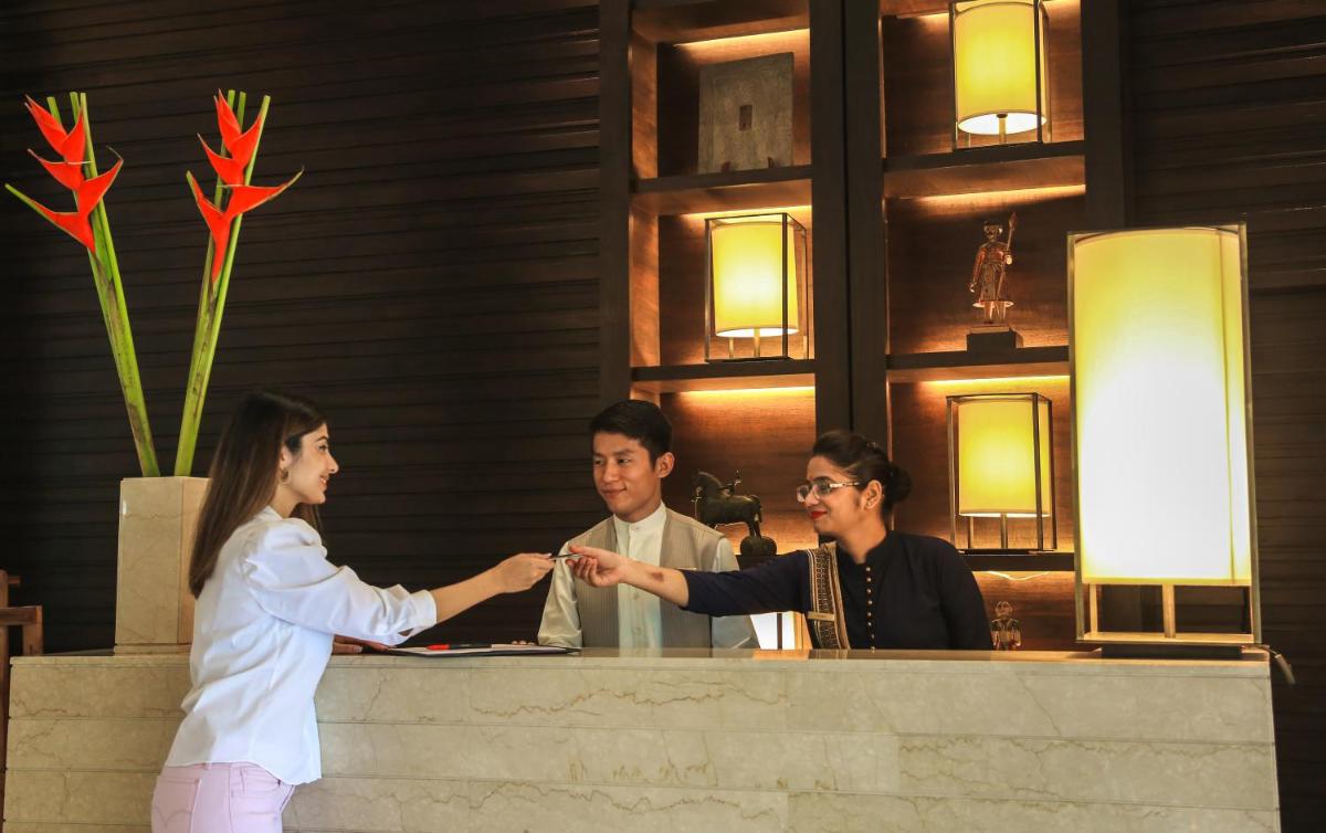 a woman shaking hands with a man at a counter at Trident Agra in Agra