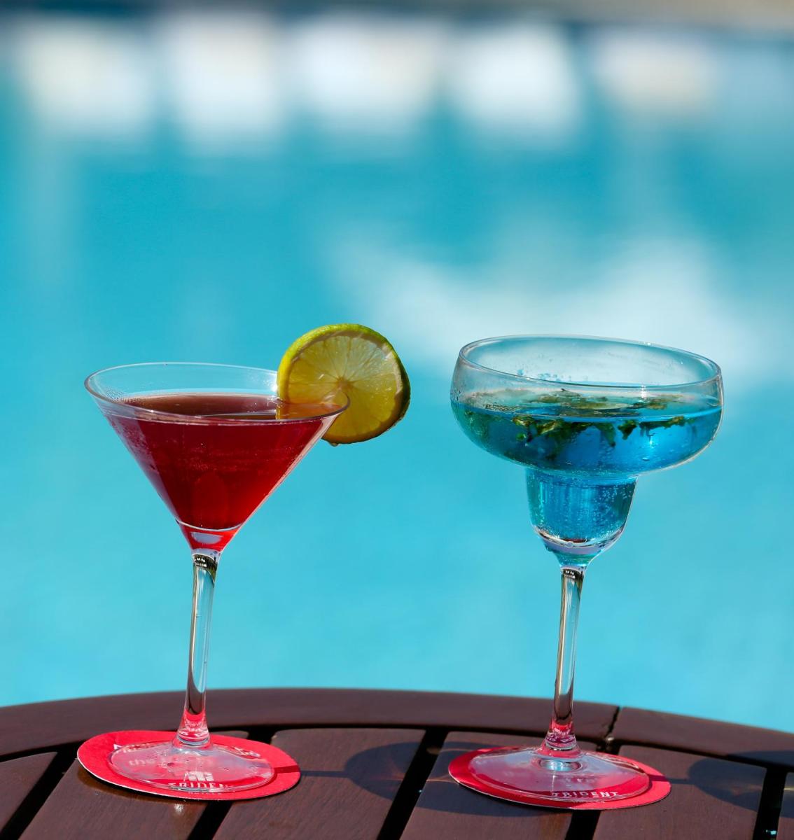 two cocktails on a table next to a pool at Trident Agra in Agra
