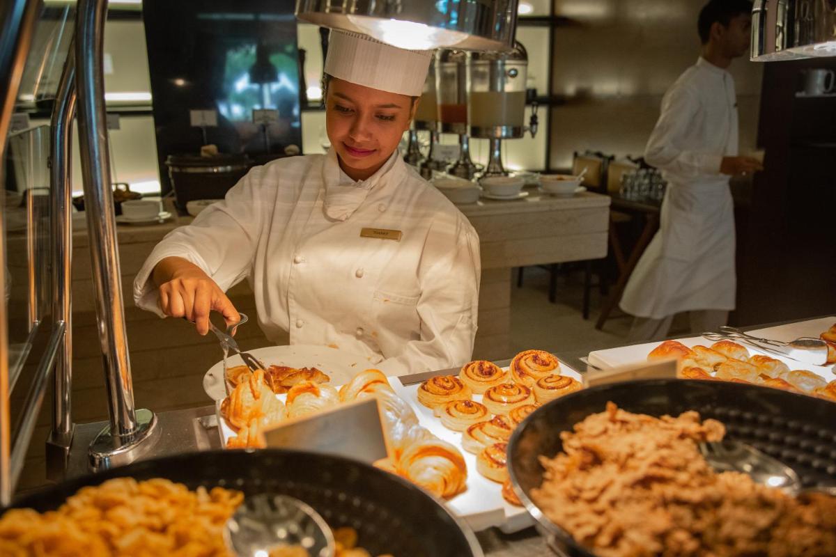 a chef is preparing food in a kitchen at Trident Agra in Agra