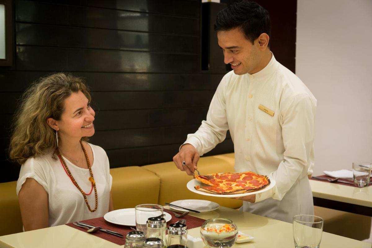 a man is serving a pizza to a woman at Trident Agra in Agra