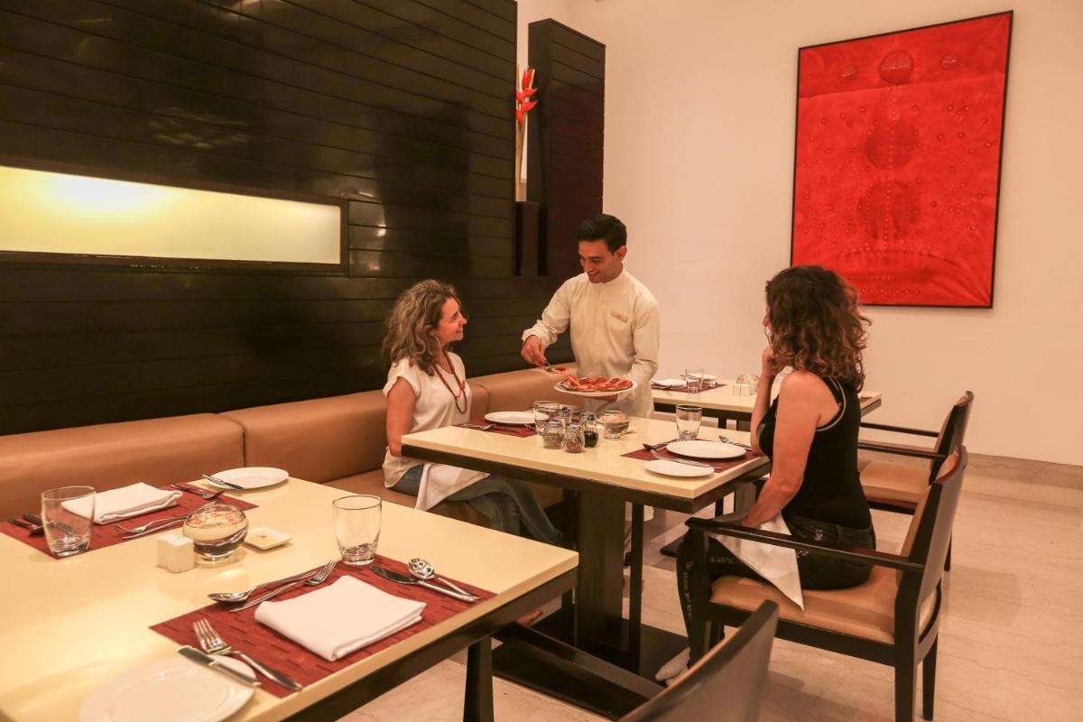 a group of people sitting at a table in a restaurant at Trident Agra in Agra