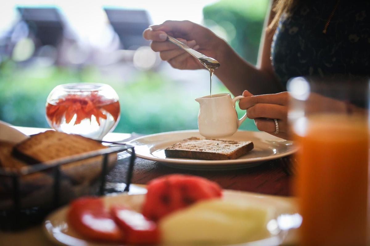 a person eating food with a cup of coffee on a table at Trident Agra in Agra