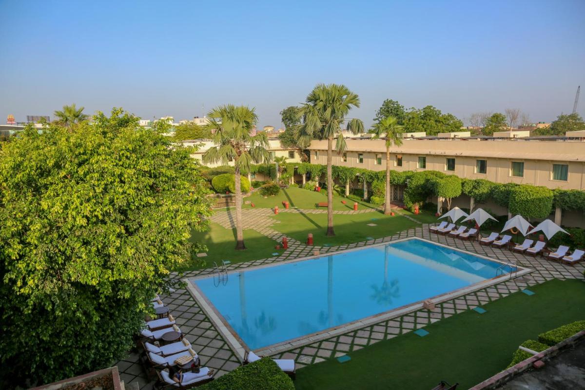 an overhead view of a resort pool with lounge chairs and trees at Trident Agra in Agra