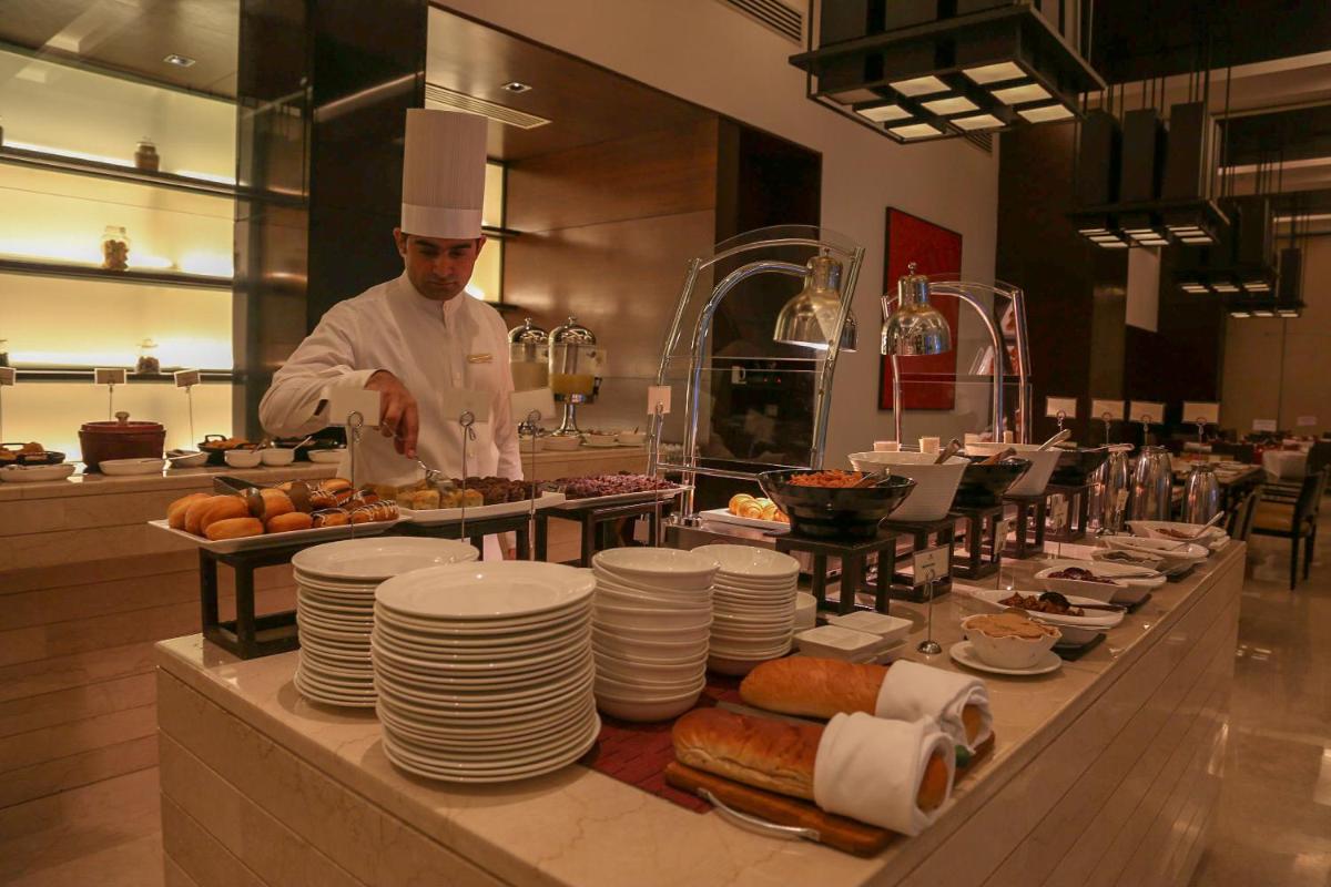 a chef preparing food in a restaurant kitchen at Trident Agra in Agra