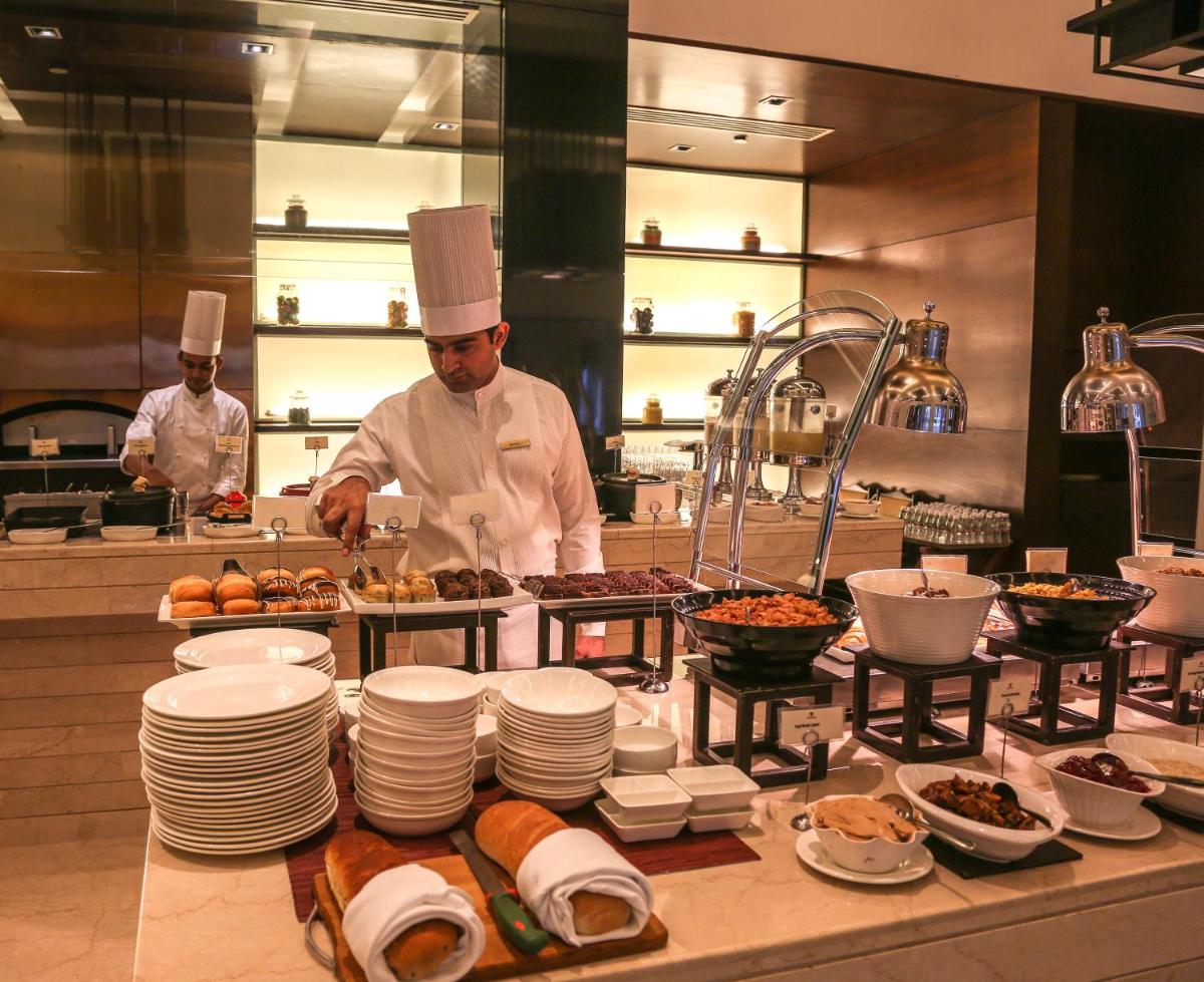 a chef in a kitchen preparing food in a kitchen at Trident Agra in Agra