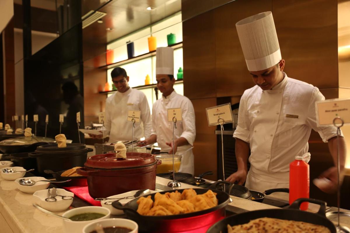 a group of chefs in a kitchen preparing food at Trident Agra in Agra