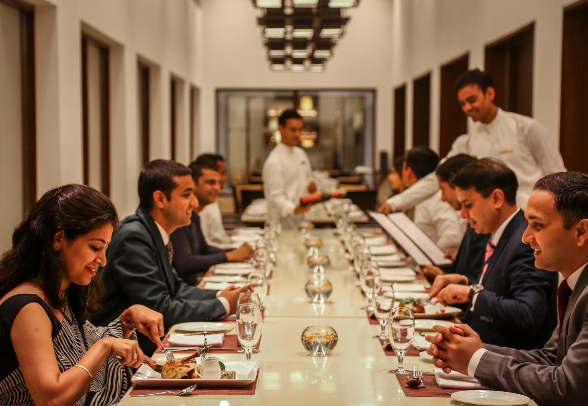 a group of people sitting at a long table at Trident Agra in Agra