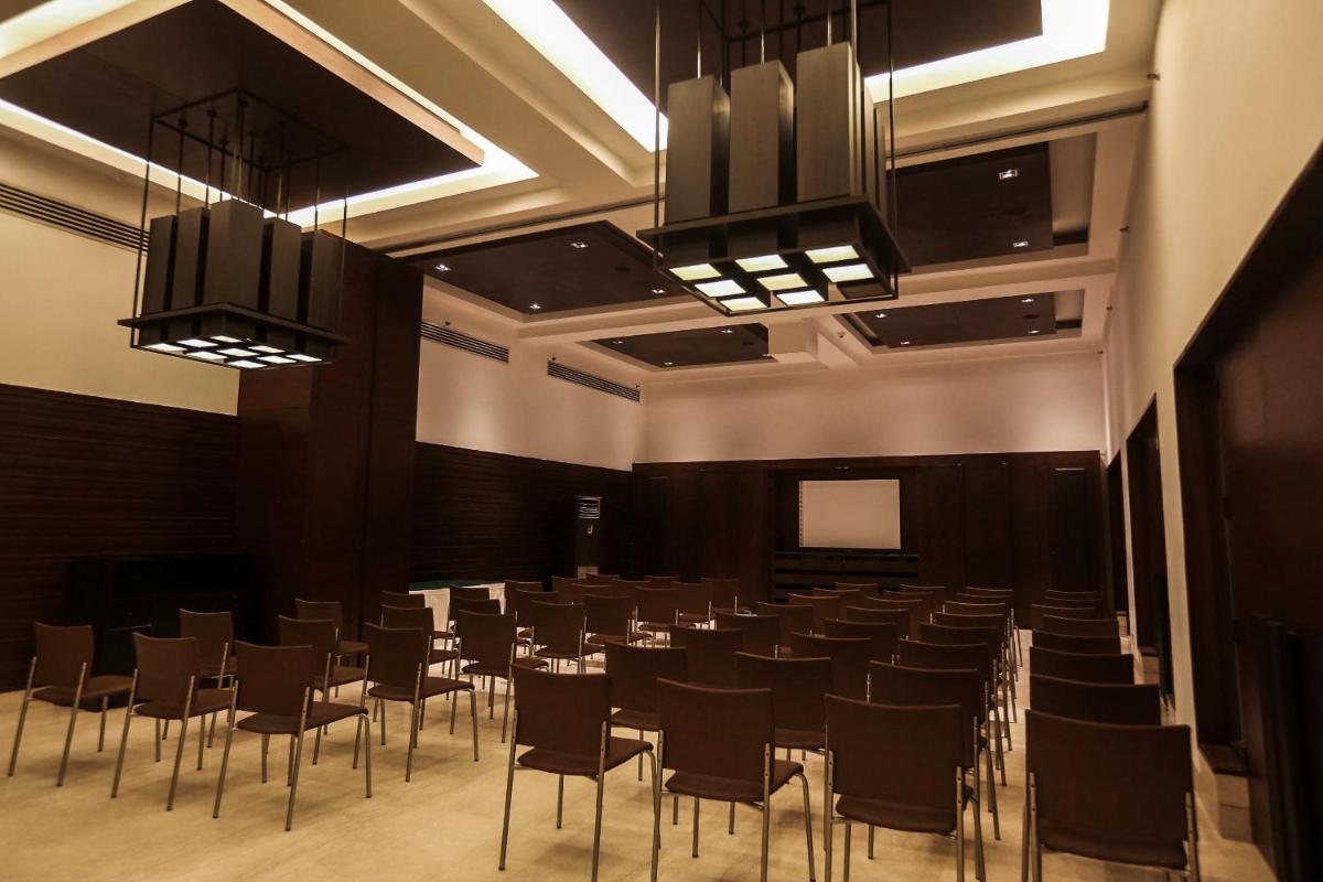 a large room with chairs and a screen in it at Trident Agra in Agra