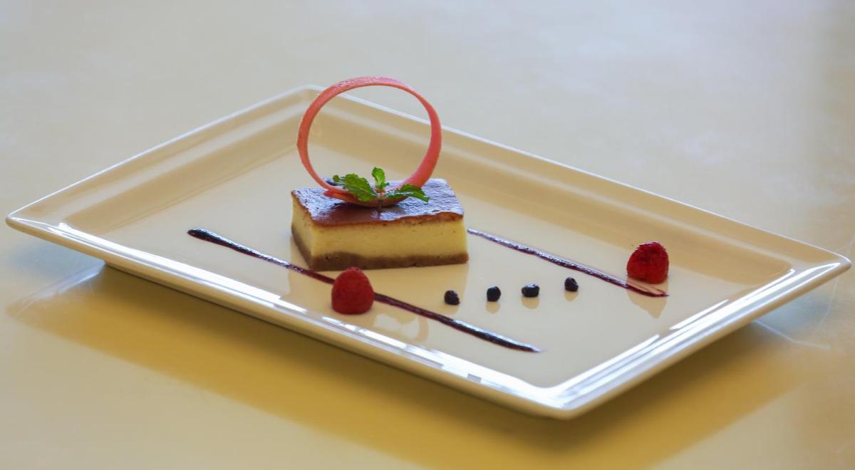 a plate with a piece of cake and strawberries on it at Trident Agra in Agra